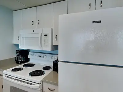 a kitchen with a white refrigerator and a white microwave at Long Beach Resort Tower III #602 in Panama City Beach