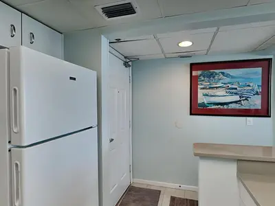 a kitchen with a refrigerator and a painting on the wall at Long Beach Resort Tower III #602 in Panama City Beach