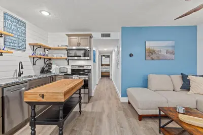 a kitchen and living room with a couch and a table at Little Palm Unit A in Panama City Beach