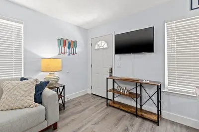 a living room with a couch and a flat screen tv at Little Palm Unit A in Panama City Beach