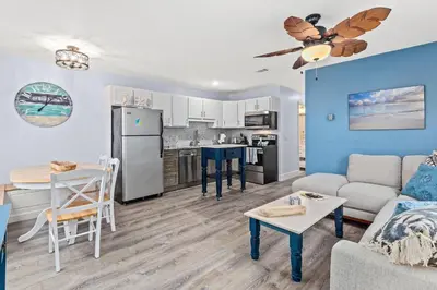 a living room and kitchen with a couch and a table at Top Shelf 47 Unit C in Panama City Beach