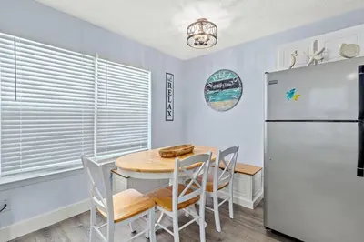 a kitchen with a table and a refrigerator at Top Shelf 47 Unit C in Panama City Beach