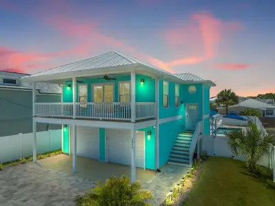 a blue house with a porch and a balcony at Heated Pool & Pet Friendly - Minutes To Beach - Spacious Backyard - FLPCB38 in Panama City Beach