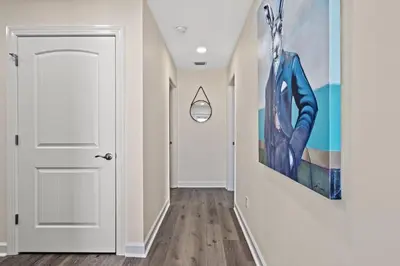 a hallway with a white door and a painting on the wall at Heated Pool & Pet Friendly - Minutes To Beach - Spacious Backyard - FLPCB38 in Panama City Beach