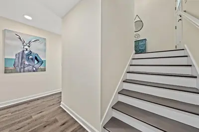 a staircase in a home with white walls and wood floors at Heated Pool & Pet Friendly - Minutes To Beach - Spacious Backyard - FLPCB38 in Panama City Beach