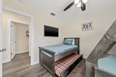 a room with a bed and a flat screen tv at Heated Pool & Pet Friendly - Minutes To Beach - Spacious Backyard - FLPCB38 in Panama City Beach