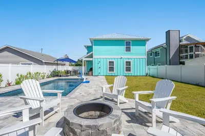 a patio with chairs and a fire pit in front of a house at Heated Pool & Pet Friendly - Minutes To Beach - Spacious Backyard - FLPCB38 in Panama City Beach