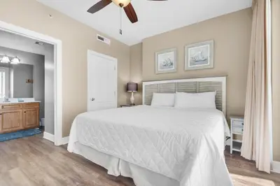 a bedroom with a white bed and a ceiling fan at Ocean Villa 803 in Panama City Beach