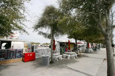 a sidewalk with tables and trees and a food truck at Village of South Walton E303 in Rosemary Beach