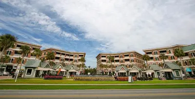 a row of apartment buildings with palm trees and a street at Village of South Walton E303 in Rosemary Beach