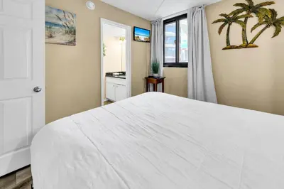a bedroom with a large white bed and a window at Sunbird 211E in Panama City Beach