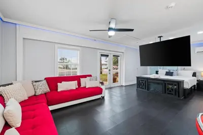 a living room with a red couch and a flat screen tv at Splash Pad by Book That Condo in Panama City Beach