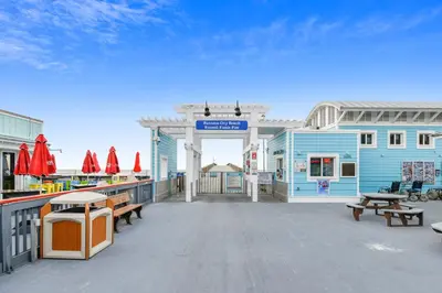 a large deck with benches and a blue building at Splash Pad by Book That Condo in Panama City Beach