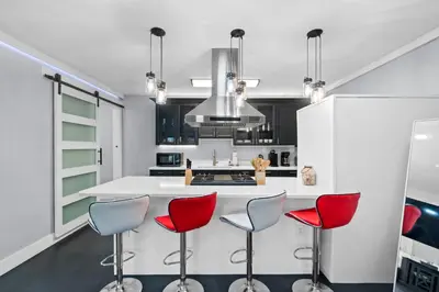 a kitchen with red chairs and a white counter at Splash Pad by Book That Condo in Panama City Beach