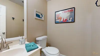 a bathroom with a toilet and a poster on the wall at Near Pier Park and Beach - Pools Onsite - FLPCB66 in Panama City Beach