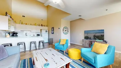 a living room with a table and chairs and a kitchen at Near Pier Park and Beach - Pools Onsite - FLPCB66 in Panama City Beach