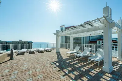 a patio with chairs and a pergola on a roof at Laketown Wharf 116 in Panama City Beach