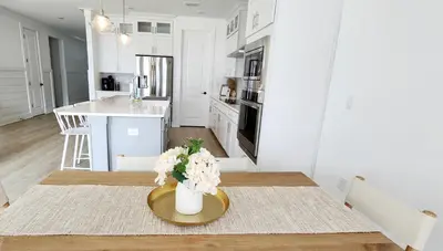 a kitchen with a table with a vase of flowers on it at Flounder by the Sea in Panama City Beach