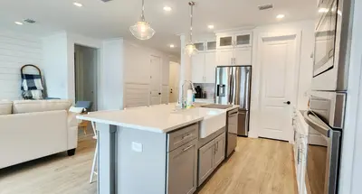 a kitchen with white cabinets and a kitchen island at Flounder by the Sea in Panama City Beach