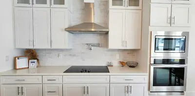 a kitchen with white cabinets and a stove top oven at Flounder by the Sea in Panama City Beach