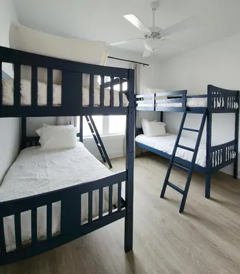 a room with three bunk beds and a fan at Flounder by the Sea in Panama City Beach