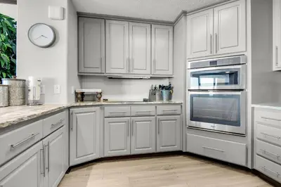 a kitchen with white cabinets and stainless steel appliances at Hidden Dunes 901 in Panama City Beach