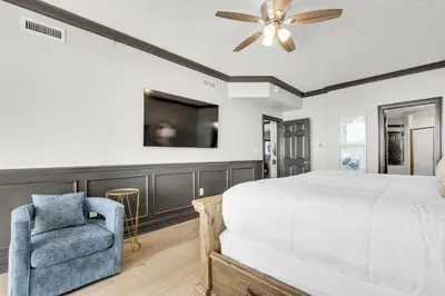 a bedroom with a bed and a ceiling fan and a chair at Hidden Dunes 901 in Panama City Beach