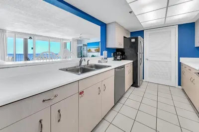 a kitchen with a sink and a refrigerator at Long Beach Resort 1-1203 in Panama City Beach