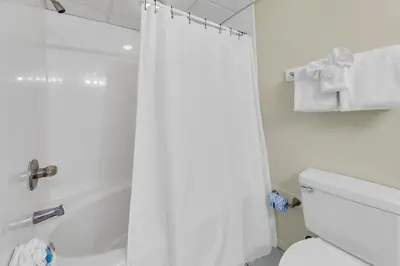 a bathroom with a white shower curtain and a toilet at Long Beach Resort 1-1203 in Panama City Beach
