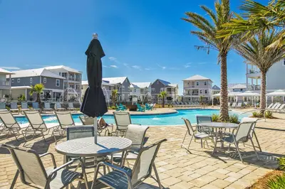 a patio with tables and chairs next to a pool at Long Beach Resort 1-1203 in Panama City Beach