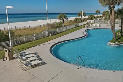 a swimming pool with chairs next to a beach at Long Beach Resort 1-1203 in Panama City Beach