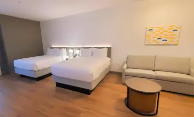 a hotel room with two beds and a couch at Comfort Inn & Suites Panama City Beach - Pier Park Area in Panama City Beach