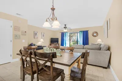 a dining room and living room with a table and chairs at Gulf Highlands 220 in Panama City Beach