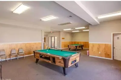 a billiard room with a pool table and chairs at Keep Palm and Carry On - 5 min walk to beach in Panama City Beach