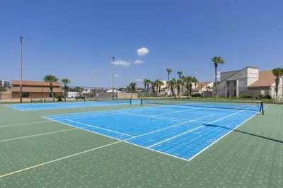 a tennis court with a net on top of it at Keep Palm and Carry On - 5 min walk to beach in Panama City Beach