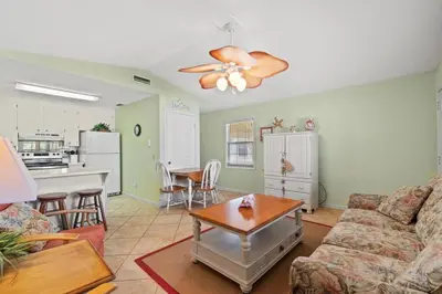 a living room with a couch and a table at Keep Palm and Carry On - 5 min walk to beach in Panama City Beach