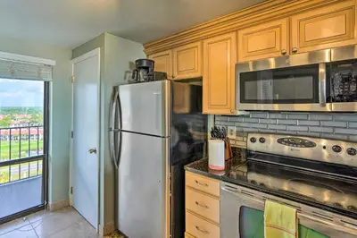 a kitchen with a stainless steel refrigerator and a window at Idyllic PCB Condo with Pool Access and Ocean Views! in Panama City Beach