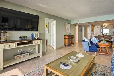 a living room with a table and a kitchen at Idyllic PCB Condo with Pool Access and Ocean Views! in Panama City Beach