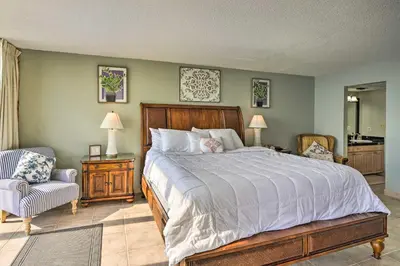 a bedroom with a large bed and a chair at Idyllic PCB Condo with Pool Access and Ocean Views! in Panama City Beach
