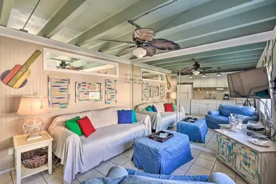 a living room with a couch and a tv at Steps to Sand, Pool Access Cozy Panama City Condo in Panama City Beach