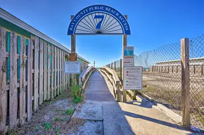 a sign on a bridge with a fence at Steps to Sand, Pool Access Cozy Panama City Condo in Panama City Beach