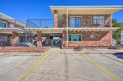 an empty parking lot in front of a brick building at Steps to Sand, Pool Access Cozy Panama City Condo in Panama City Beach
