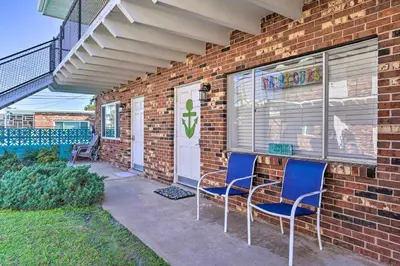 a brick house with two chairs and a door at Steps to Sand, Pool Access Cozy Panama City Condo in Panama City Beach