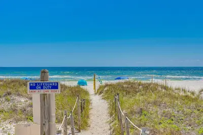 a no entry sign on a sandy beach at Steps to Sand, Pool Access Cozy Panama City Condo in Panama City Beach