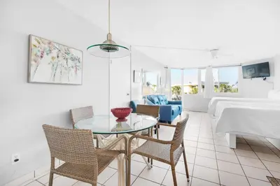 a living room with a table and chairs and a bed at Top of the Gulf 208 in Panama City Beach