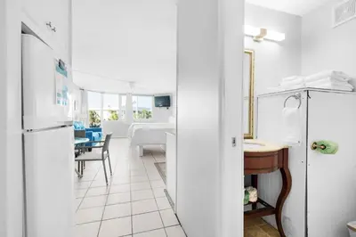 a kitchen and dining room with a refrigerator and a table at Top of the Gulf 208 in Panama City Beach