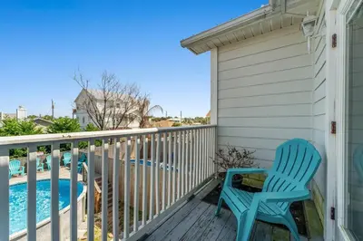 a blue chair sitting on a deck next to a swimming pool at Shells and Bells Ocean Paradise - Sleeps 24, 2 Private Pools in Panama City Beach