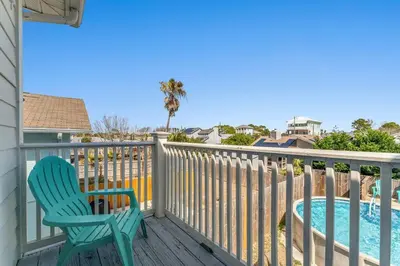 a blue chair sitting on a deck next to a swimming pool at Shells and Bells Ocean Paradise - Sleeps 24, 2 Private Pools in Panama City Beach