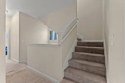 a staircase in a home with white walls and carpet at Shells and Bells Ocean Paradise - Sleeps 24, 2 Private Pools in Panama City Beach