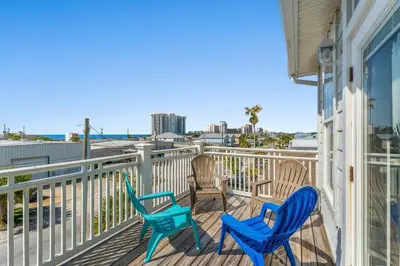 a balcony with three chairs and a view of the ocean at Shells and Bells Ocean Paradise - Sleeps 24, 2 Private Pools in Panama City Beach